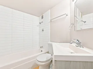 Bathroom with tub and vanity at Julian Square Apartments