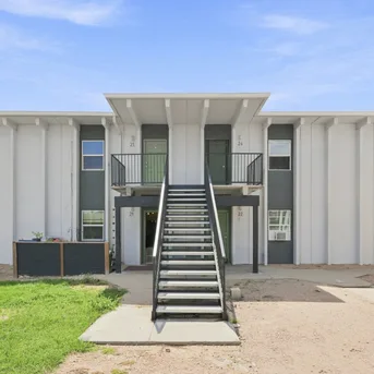 Julian Square Apartments building front view with green entry doors