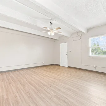 Julian Square Apartments living room with ceiling fan and beams